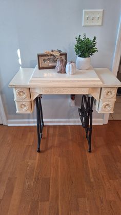 an antique sewing table is painted white