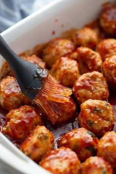 a spatula is being used to stir meatballs