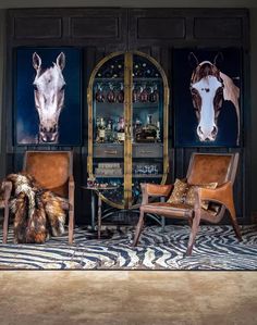 two brown chairs sitting next to each other on top of a zebra rug