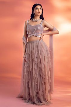 Grey-pink lehenga featuring multi ruffles and a crisscross waistband. Paired with a sequined padded blouse and an embellished dupatta with crystal drops., Fit: Relaxed Festive Pink Ruffled Anarkali Set, Glamorous Ruffles Sets For Party, Glamorous Ruffled Party Sets, Anarkali Lehenga With Ruffles For Reception, Glamorous Wedding Lehenga With Ruffles, Glamorous Festive Lehenga With Ruffles, Anarkali Ruffled Choli For Reception, Anarkali Choli With Ruffles For Reception, Festive Pink Lehenga With Ruffles