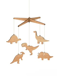 three wooden dinosaurs are hanging from the ceiling, and one is holding a toy airplane