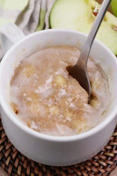 a bowl of oatmeal is sitting on a woven place mat with an apple in the background