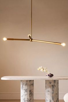 an elegant dining room with marble table and gold chandelier hanging from the ceiling