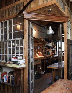 the inside of a wooden building with lots of glass doors and shelves on each side