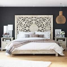 a bedroom with black walls and white bedding, wooden headboard and night stand