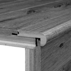 a close up view of the side of a wooden table with an angled edge and wood grain