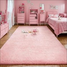 a bedroom with pink furniture and decor in it's color scheme, including a rug on the floor