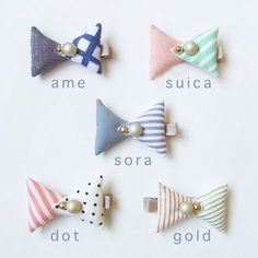 four different colored bow clips with pearls on them