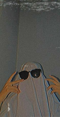 a woman wearing sunglasses is covering her face