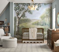 a baby's room with a tree mural on the wall