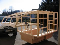 a white truck parked next to a wooden structure in the middle of a parking lot