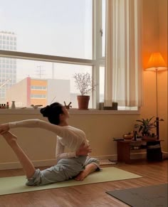 a woman doing yoga in front of a window