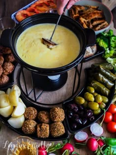 a table topped with lots of different types of food next to bowls of meatballs and veggies