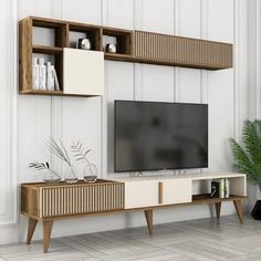 a living room with white walls and wooden shelves on either side of the tv screen