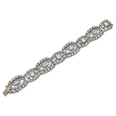 When baguette diamonds—those linear, sleek, rectangular fancy cut stones that reached their height of popularity in the 1920s—are used to deftly drive the dynamic movement within a jewelry composition, it borders on pure poetry. This Vintage Diamond Articulated Bracelet is made in the middle of the XX century, circa 1960s, however, it certainly demonstrates a dexterity and technical prowess associated with multiple glorious jewelry periods from the last two centuries. Crafted in 18K white gold, the bracelet features baguette-, emerald-, round brilliant-, and marquise-cut white diamonds with an estimated total weight of 38.00 carats. The diamonds are not certified and are equivalent to D-F color and VS clarity. Within the 6.63-inch long (16.84 cm) bracelet, lyrical fluid lines of baguette d Jewelry Composition, Vintage Diamond Bracelet, Diamond Gold Bracelet, Hall Of Mirrors, Dynamic Movement, Bracelet Tennis, Baguette Diamonds, Baguette Cut Diamond, Edwardian Era