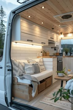 the interior of a camper van with its door open to reveal a kitchen and living area