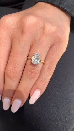 a woman's hand with a ring on it and a diamond in the middle