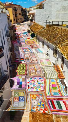 an artisticly painted walkway in the middle of a town with buildings and balconies