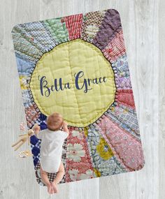 a baby laying on top of a quilt with the words build grace written on it