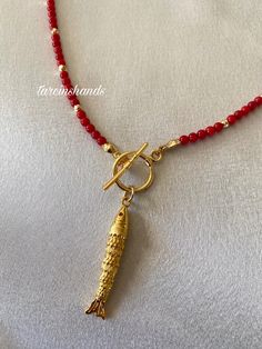 ✨ Gold-Plated Necklace with Tiny Red Coral and Movable Fish Pendant - 18" This delicate and stylish gold-plated necklace combines minimalist elegance with a touch of playful charm. Featuring tiny red coral beads and a unique movable fish pendant, it's perfect for adding a subtle yet eye-catching detail to any outfit. 💎 High-Quality Materials: The necklace is crafted with gold-plated chains and adorned with vibrant red coral, symbolizing energy and vitality. The movable fish pendant adds a dynamic element, making this piece truly one of a kind. 📏 Perfect Length: Measuring 18 inches, this necklace sits gracefully on the collarbone, making it ideal for layering or wearing as a standalone statement. 🎨 Timeless Minimalism: Designed for those who appreciate clean lines and subtle details, thi Coral Necklace Designs, 3d Fish, Red Beaded Necklaces, Red Coral Necklace, Autumn Necklace, Necklace Trendy, Fish Necklace, Fish Pendant, Coral Pendant