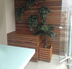 a bath tub sitting next to a wooden planter on top of a tiled floor