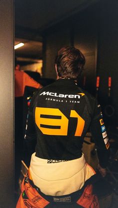 the back of a motorcycle rider wearing an orange and black jersey