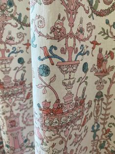 an upholstered curtain with colorful designs and animals on it's side, in front of a white background