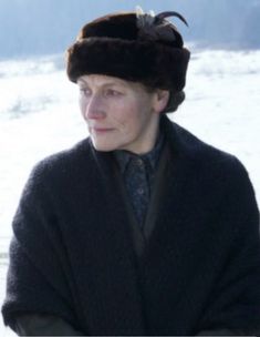 an older woman wearing a fur hat and coat