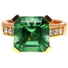 an emerald and diamond ring set in yellow gold