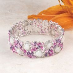 A magical display of color...This stunning bracelet is adorned with 36 amethysts, 324 white topaz, 82 created pink sapphires, and 16 moonstones. With over 450 meticulously placed stones totaling more than 43 carats in all, this bracelet is truly a masterpiece!The bracelet is plated in a combination of platinum and rhodium, ensuring a brilliant and enduring finish that perfectly complements the abundance of stones.The Cherry Blossom Bracelet is more than just jewelry; it's a captivating statement White Bracelets With Sparkling Stones In Fine Jewelry Style, White Bracelets With Sparkling Stones Fine Jewelry, Fine Jewelry White Bracelets With Sparkling Stones, Elegant White Gemstones With Accents, White Bracelet With Sparkling Stones For Anniversary, White Gemstones With Accents Fine Jewelry, White Cubic Zirconia Jewelry With Gemstone Accents, Fine Jewelry White Gemstone Bracelets, Fine Jewelry White Bracelets With Gemstone