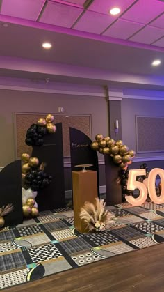 the 50th birthday party is decorated with balloons and streamers in black, gold and white