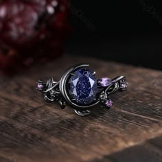 Oval cut Blue Sandstone engagement ring set unique Moon style amethyst cluster ring gothic black gold rings for women leaf branch rings -----Ring Information----- ✦Engagement Ring Metal Type: 925 sterling silver, 10K/14K/18K Solid Gold, Platinum Center stone: Blue sandstone Stone size: 6x8mm oval cut Side stone: amethyst ✦Wedding Band Stone: Round amethyst  ✦ Please feel free to contact me if you have any questions or you are interested in custom order. ✦Black rhodium plating: Rhodium, a valuabl Black Wedding Jewelry With Birthstone, Black Birthstone Jewelry For Wedding, Black Birthstone Jewelry For Promise Ring, Mystical Black Metal Jewelry, Black Sterling Silver Celestial Jewelry, Celestial Black Sterling Silver Jewelry, Celestial Style Rose Cut Diamonds Jewelry Gift, Black Sapphire Fine Jewelry, Purple Amethyst Jewelry With Rose Cut Diamonds