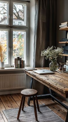 a wooden desk sitting in front of a window next to a book shelf filled with books