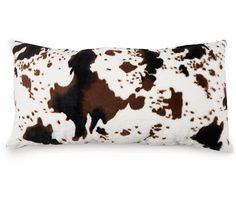 a brown and white cow print pillow on a white background