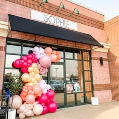 there is a large balloon sculpture outside of the store front door that says sophie