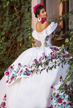 Dance the night away in this floral charro off the shoulder ball gown with A-line split front skirt by Ragazza Fashion M41-141. This beautiful long off the shoulder dress features an illusion V-neck bodice adorned with sequined and beaded floral appliques, short sleeves, open lace-up corset back, and a floor length A-line skirt with a sweep train. Floral Charro Off Shoulder Quinceanera Dress by Ragazza M41-141 Designer: Jazmín Collection by Ragazza Fashion 2023 Style Number: M41-141 Colors: Ivor White Charro Quinceanera Dresses, Mexican Theme Dresses, Charro Dress, Long Off The Shoulder Dress, Quinceanera Dresses Mexican, Split Front Skirt, Vestido Charro, Mexican Quinceanera, Mexican Quinceanera Dresses