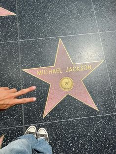 a person standing in front of a star on the hollywood walk of fame with their hand out