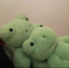 two green stuffed animals sitting next to each other