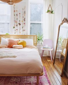 a bedroom with white walls and wooden floors