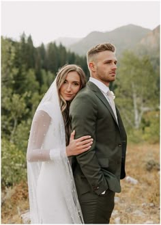 a bride and groom standing in the mountains