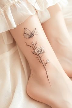 a woman's foot with flowers and butterflies tattoo on the side of her leg