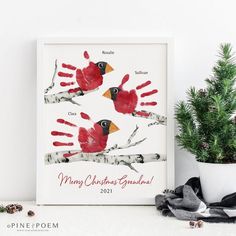 a christmas card with handprints of two red birds and the words merry christmas grandma