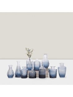 a group of blue vases sitting next to each other on a white counter top