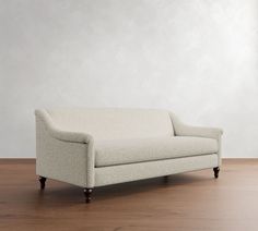 a white couch sitting on top of a wooden floor