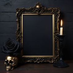 a gold frame with a candle and a skull statue next to it on a table