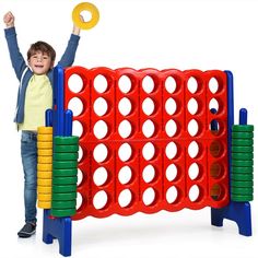 a young boy standing next to a giant board game with lots of circles on it