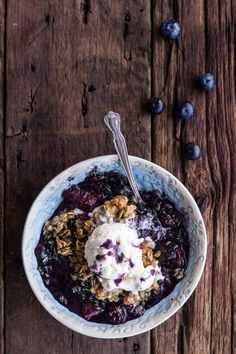 a bowl filled with blueberries and yogurt on top of a wooden table