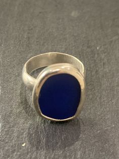 A hand made sterling silver ring set with a piece of cobalt blue coloured sea glass.  The sea glass is set into a fine silver bezel mounted on a sterling silver Band . The band is a 5mm half circle profile band..The ring is size a smaller size, O or US size 7.25 Silver Rings Blue Stone, Adjustable Silver Ring With Sea Glass, Silver Recycled Glass Ring, Minimalist Nickel-free Blue Ring, Silver Smithing Jewelry, Circle Profile, Silver Gemstone Rings, Seaglass Jewelry, Sea Glass Ring