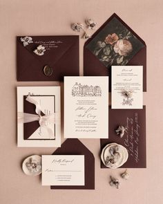 the wedding stationery is laid out on top of each other, including two envelopes and