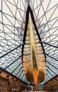 the inside of a building that has a very large boat hanging from it's ceiling